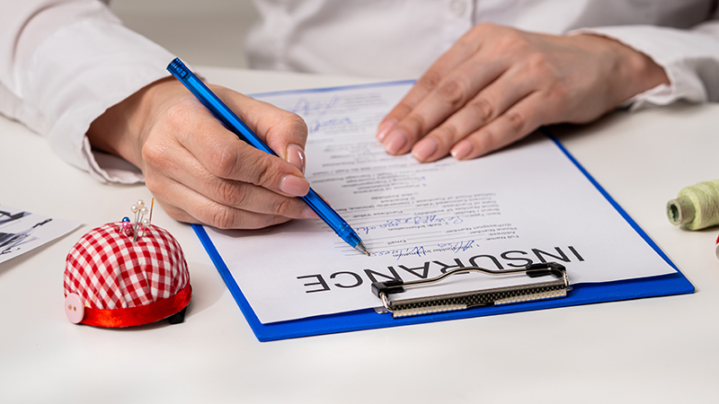 Person signing an insurance document – representing contractor build coverage and equipment liability protection