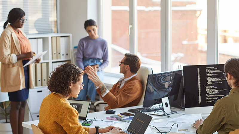 Team meeting inside a modern office discussing commercial builders insurance for upcoming construction work.